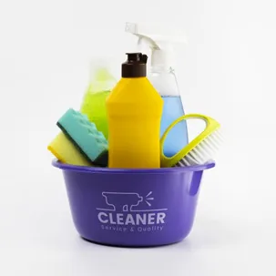 A purple bucket filled with various cleaning supplies including bottles and sponges.
